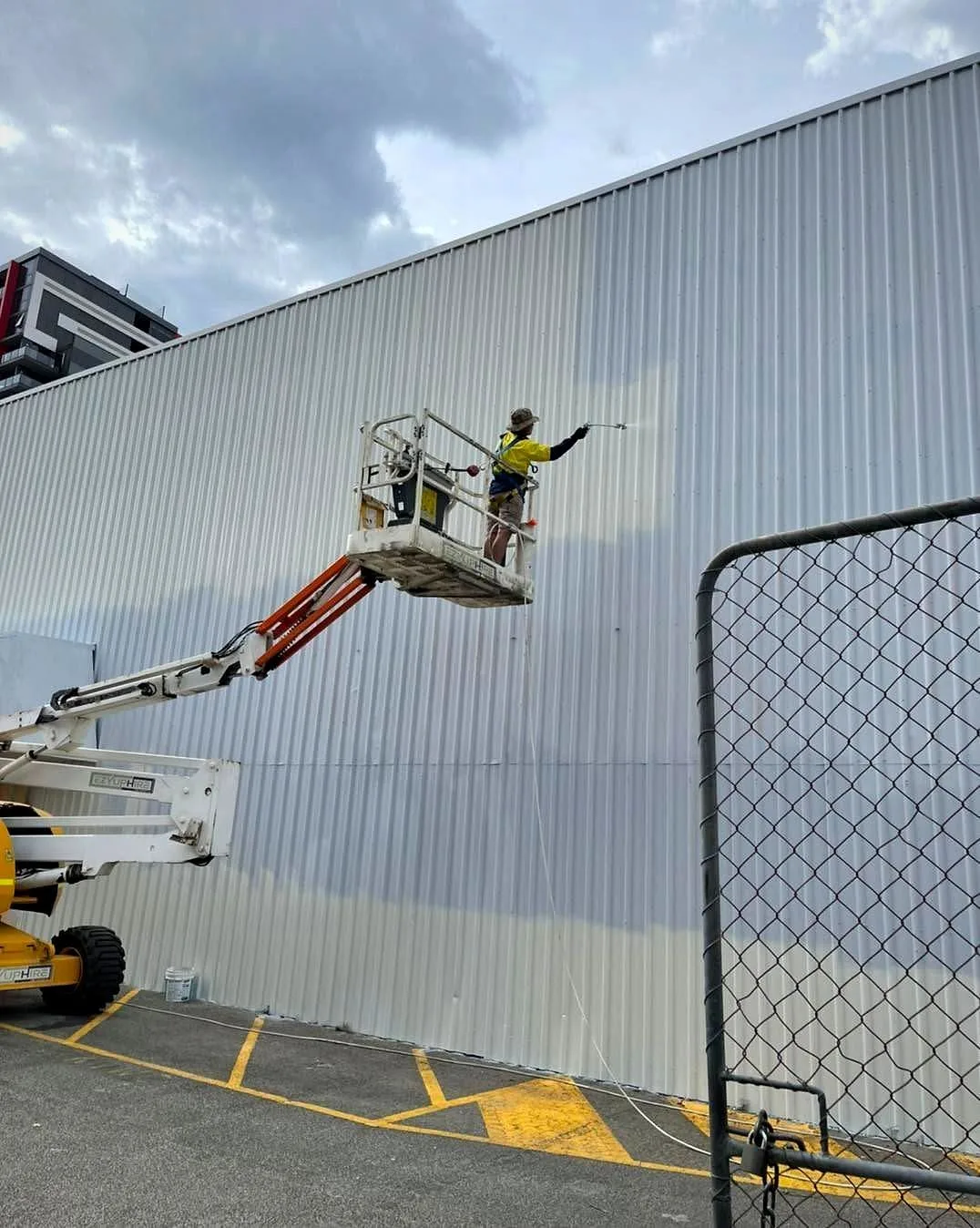 Industrial painting on a steel shed with access equipment